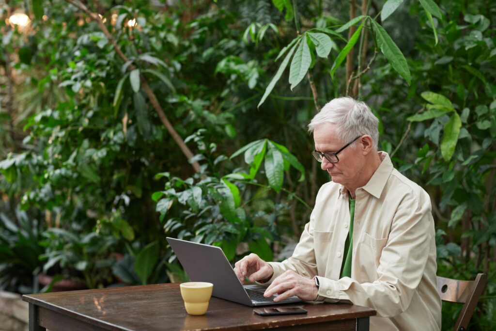 “Retired professional working freelance on laptop outdoors”