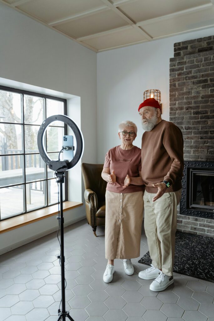 “Retired couple recording video content at home using simple camera and lighting setup”